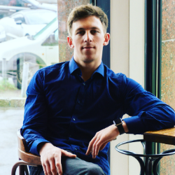 portrait-young-man-sitting-chair-against-window