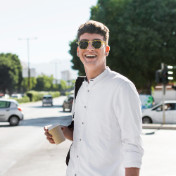 smiley-man-with-sunglasses-having-coffee-outdoors-city